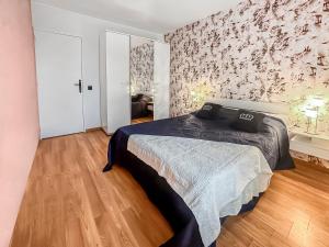 een slaapkamer met een bed en een muur met bloemen bij La Belle Époque d'Annecy in Annecy