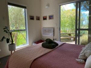 a bedroom with a large bed with a large window at The Willow Guest Suite in Dunedin