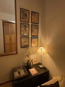 a room with a table with a lamp and pictures on the wall at Maribel Confort in Sierra Nevada