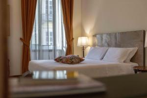 a bed in a hotel room with a window at Hotel Bologna in Turin