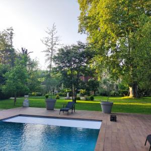 una piscina con un banco junto a un jardín en Manoir La Barriere - Lot, en Le Vigan