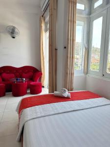 a bedroom with a large bed and a red couch at GOLDEN TWO Hotel in Vung Tau