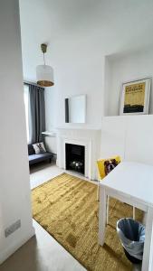 a white living room with a white table and a fireplace at Glenmore Suites in London