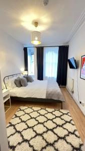 sypialnia z dużym łóżkiem i dywanem w obiekcie Glenmore Suites w Londynie