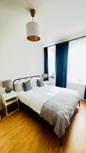 a bedroom with a large bed with blue curtains at Glenmore Suites in London