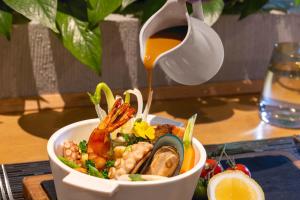 uma tigela de comida com marisco e um pote de molho em Melia Hanoi em Hanói