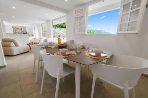 a dining room with a table and white chairs at Villa Alexina in Le Robert