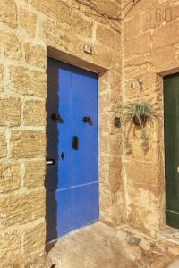 a blue door on the side of a stone building at The Blue Village Suites by 360 Estates in Żejtun