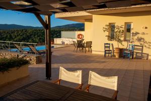 a patio with chairs and tables on a house at Villa Poppy in Vathi