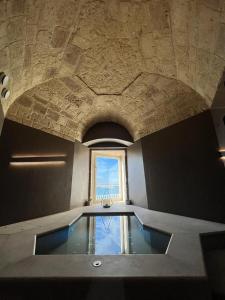 a swimming pool in a room with a window at DOGANA RESORT in Molfetta