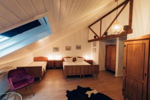 ein Schlafzimmer im Dachgeschoss mit einem Bett und ein Zimmer mit einem Bett und einem Tisch in der Unterkunft Gasthof Hotel zur Post in Egloffstein