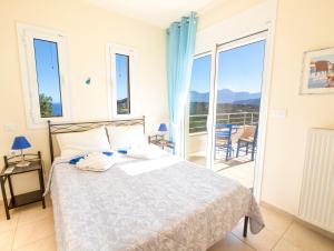 a bedroom with a bed and a balcony at Villa Poppy in Vathi