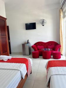 a living room with a red couch and a tv at GOLDEN TWO Hotel in Vung Tau
