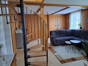 a living room with a blue couch and a staircase at Family-friendly apartment with Alpine view in Matten
