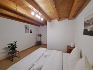 uma grande cama branca num quarto com tectos em madeira em Family-friendly apartment with Alpine view em Matten