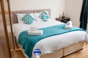 een slaapkamer met een bed met handdoeken erop bij Four Bedroom House By Beds Away Short Lets & Serviced Accommodation Oxford With Free Parking & Garden Access in Oxford