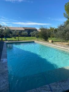a swimming pool with blue water in a yard at le Nomade en Provence in Bouchet