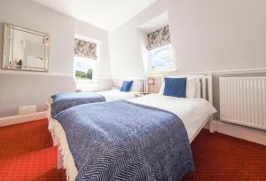 duas camas num quarto com azul e branco em Goodwin House em Keswick