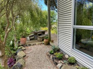 a garden with a picnic table and a window at The Willow Guest Suite in Dunedin