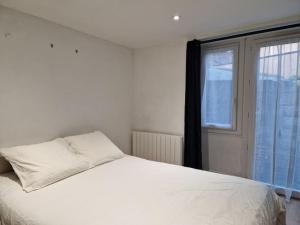 a bedroom with a white bed and a window at Loft de charme hypercentre in Angers
