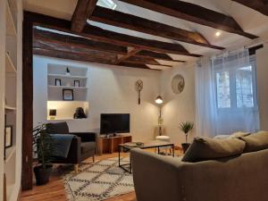 een woonkamer met een bank en een tv bij Loft de charme hypercentre in Angers