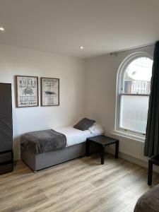 a small bedroom with a bed and a window at Stunning 2-Bed Apartment in Chelmsford in Chelmsford