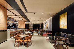 a restaurant with tables and chairs and a bar at Four Points by Sheraton Nantong, Haimen in Nantong