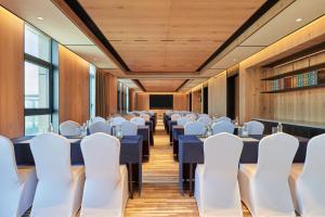 une salle de conférence avec des tables bleues et des chaises blanches dans l'établissement Four Points by Sheraton Nantong, Haimen, à Nantong