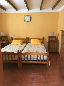 1 dormitorio con 2 camas y TV en la pared en Una casa con vistas en La Caleta