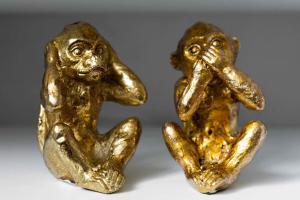 dwie złote figurki małp siedzących obok siebie w obiekcie Evergreen Cottage Orsett w mieście Orsett
