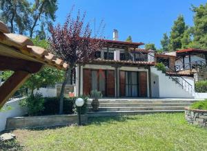 a house with a staircase in front of it at Esperides Villa in Sani Beach