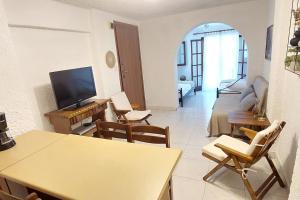a living room with a table and chairs and a television at Esperides Villa in Sani Beach