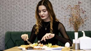 a woman sitting at a table eating a plate of food at Mai İnci Otel in Antalya