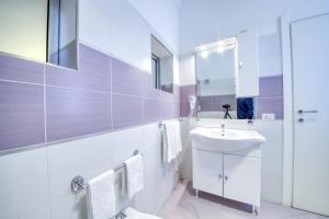 Un baño blanco con lavabo y espejo. en La Cattedrale Apartments&Suite - Affitti Brevi Italia, en Gravina in Puglia 24 fotos más