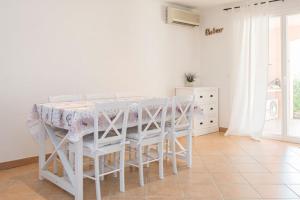 Bonheur - Vakantiewoning Côte d'Azur في روكبرون-سور-أرجينس: غرفة طعام بيضاء مع طاولة وكراسي