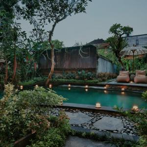 a small pool in a garden with lights at Lastana Suite Joglo Ubud in Ubud