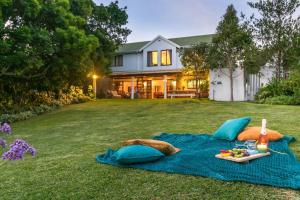 a picnic set up on a blue blanket on a lawn at Escape to Paradise in Plett - Back up Electricity in Plettenberg Bay