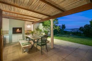 a patio with a table and chairs and a fireplace at Escape to Paradise in Plett - Back up Electricity in Plettenberg Bay