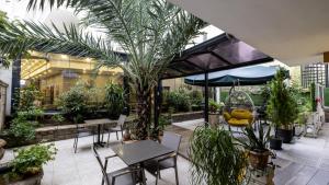 a patio with tables and chairs and plants at Mai İnci Otel in Antalya