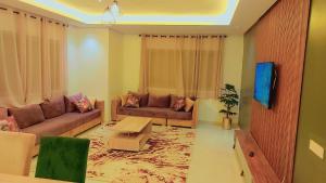 ein Wohnzimmer mit 2 Sofas und einem Tisch in der Unterkunft Appartement Perla - Costa Bouznika in Bouznika
