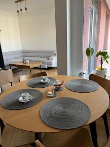 a wooden table with four plates on top of it at Apartman Usmev in Košice