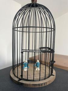 a bird cage with two figurines in it at Attico the Queen2 in Caravaggio