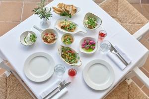 a white table with plates of food on it at Esperos Palace Resort in Faliraki