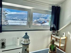 um quarto com duas janelas com vista para uma montanha nevada em Almsternderl 2.0 - gemütliches Appartment in Gosau em Gosau