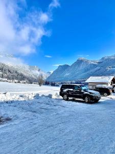 a black truck parked in a snow covered field at Almsternderl 2.0 - gemütliches Appartment in Gosau in Gosau