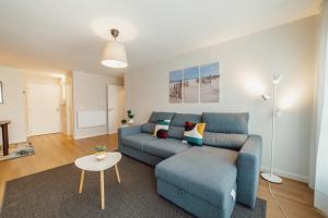 ein Wohnzimmer mit einem blauen Sofa und einem Tisch in der Unterkunft Matosinhos Premium by Hosty in Porto