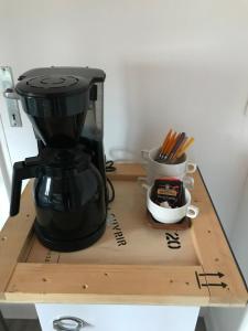 a black coffee maker sitting on a wooden cutting board at La Pause Vélo gite d'étape in Guéret