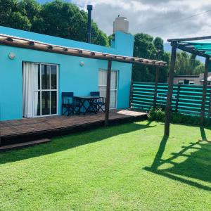 玛尔德科博Casa a 50 mts de la playa的一座蓝色的房子,在院子里设有木甲板