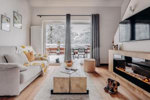 a living room with a couch and a fireplace at ISKÖ BaseCamp & Hôtel, Col d'Aubisque in Gourette