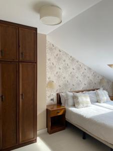 a bedroom with a bed and a wooden cabinet at Apartamentos Las Vegas in Ribadesella